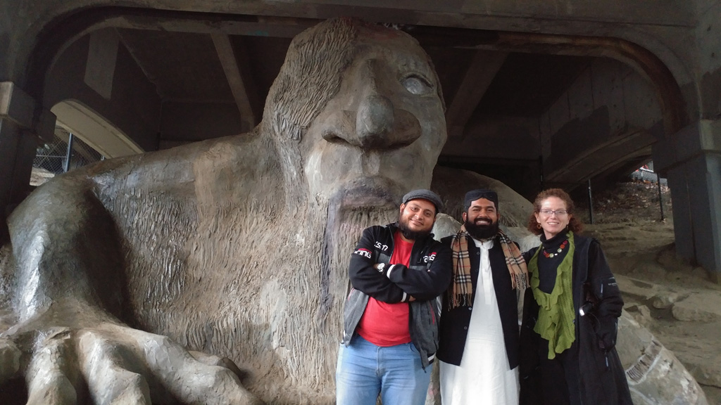 Home Hospitality host with Pakistani guests in front of Fremont Troll